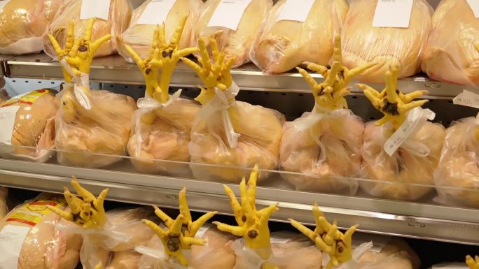 在市场或超市，柜台上有腿未割过包皮的鸡