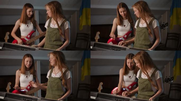 两个可爱的女孩在音乐学校上课。女孩们笑着，选择合适的旋律来演奏贝斯吉他和合成器。