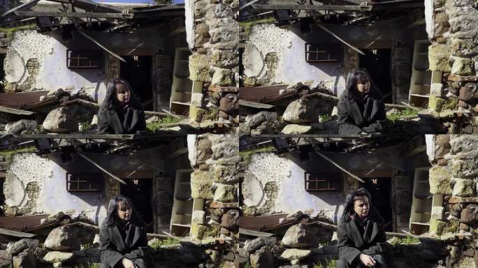 地震后，一个悲伤的女人站在她倒塌的房子旁边