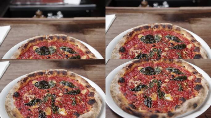 在亚利桑那州凤凰城的比安科披萨店里，盘子里放着煮熟的番茄酱披萨，视频向下倾斜。