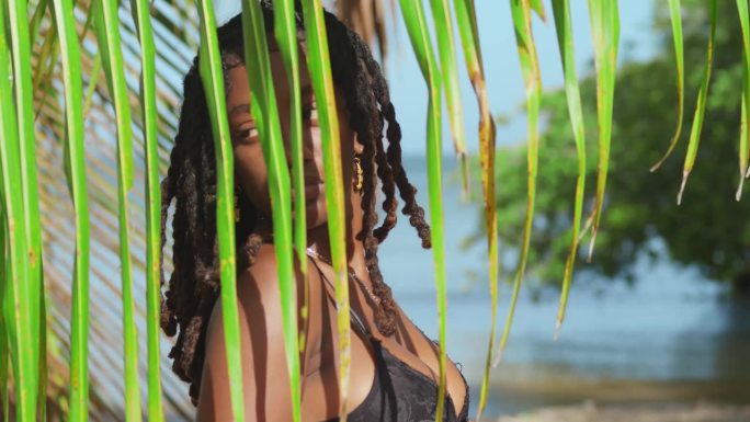 在特立尼达加勒比海岛的白色沙滩上放松，一个穿着比基尼的女孩享受着热带海滩。