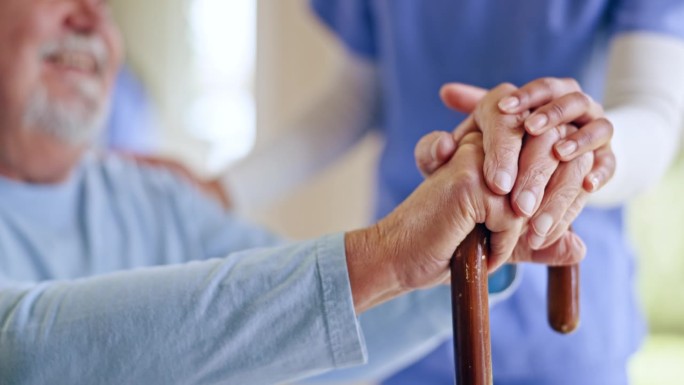 同理心，手杖和老年人的手在养老院的照顾者安慰或支持。信任、帮助和女护士抚摸残疾老人，希望他能康复