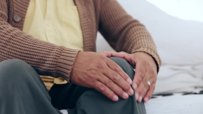 老年人，男性和按摩膝盖疼痛，损伤或骨科伤口在沙发上。特写，老年人和压腿疼痛，关节炎或骨质疏松症的肌肉