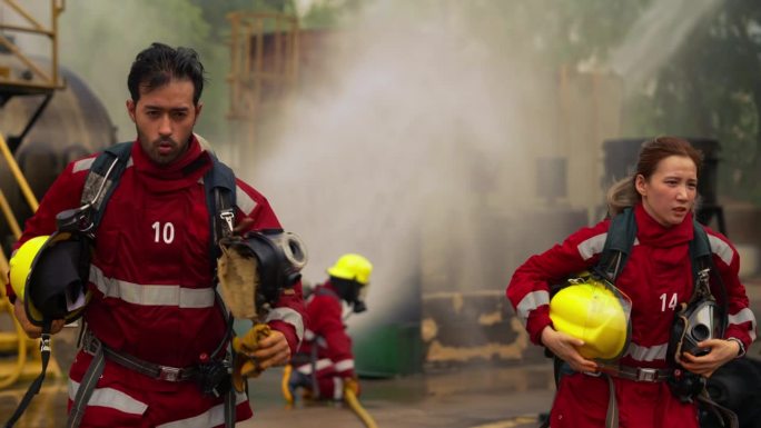 消防队员配备红色安全服、安全帽和氧气罐。
