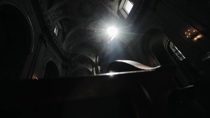 一缕光线透过古庙的窗户照进来。神奇的上帝之光射入古老的天主教堂。穹顶下的天使