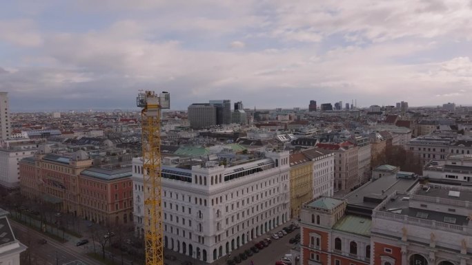 轨道拍摄围绕城市现场高塔起重机。市区建筑物的建筑工程。奥地利的维也纳