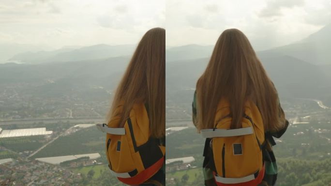 垂直视频。一名女子背着明亮的双肩包，穿着格子衬衫，用手机拍下了高山的景色。