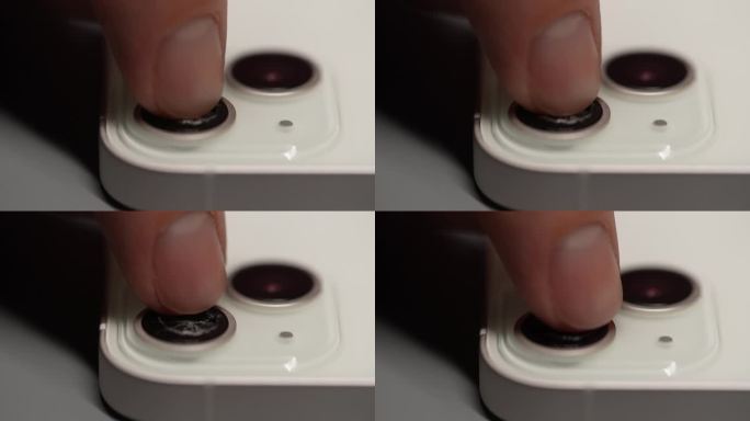 用智能手机用断指镜头拍摄的无法辨认的触摸特写。专业维修人员检查手机相机镜头的特写
