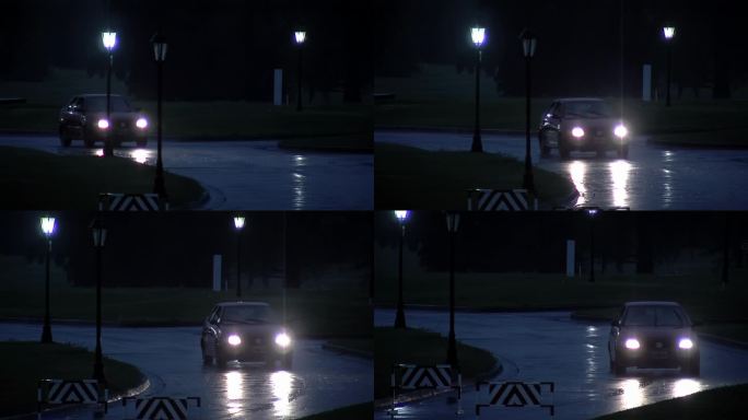 一辆汽车在雨夜行驶在有路障的路上。