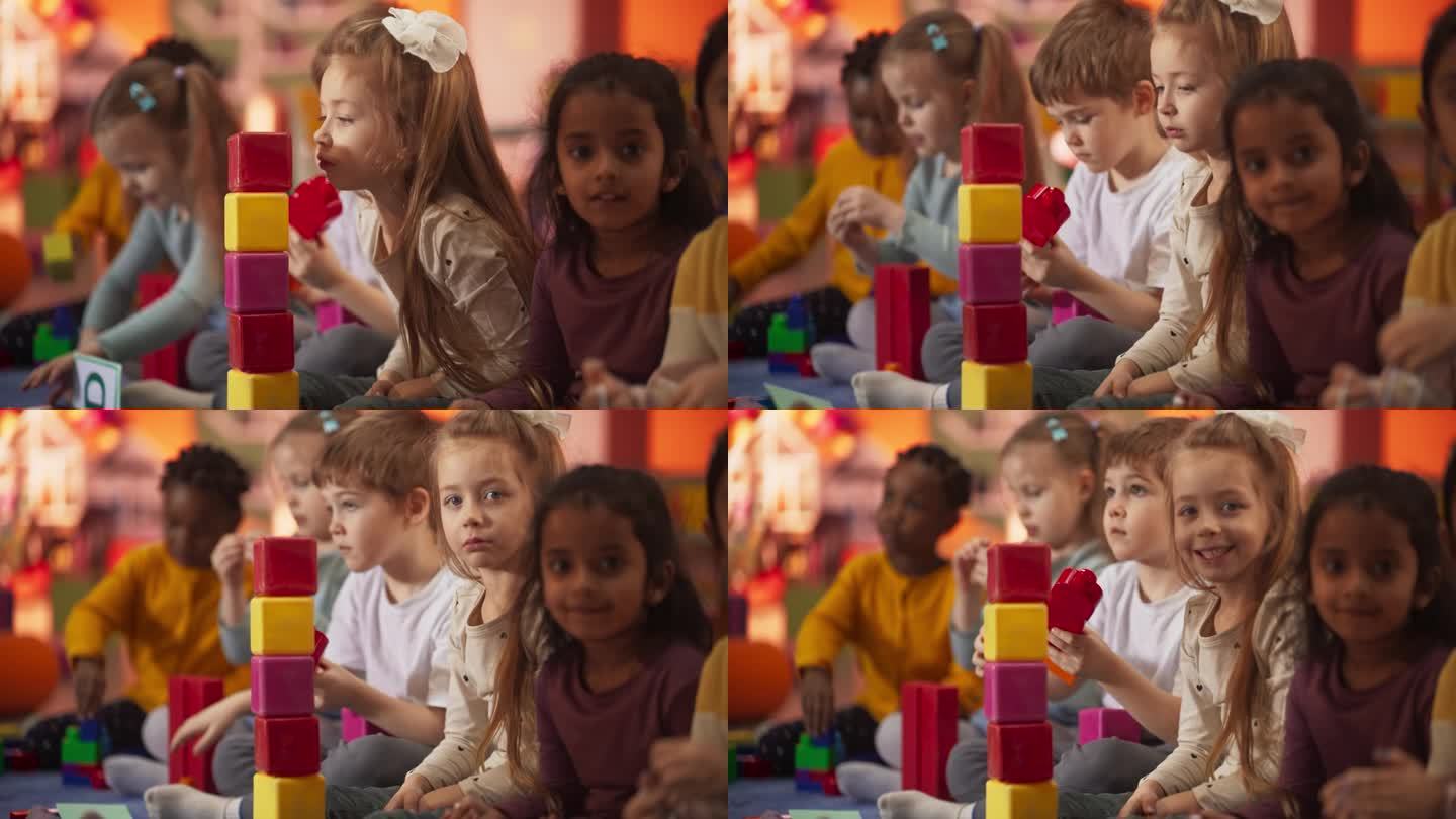 创意多民族儿童在幼儿园玩耍。小白种人女孩吹着五颜六色的积木塔。不同的孩子在现代日托中心玩得开心