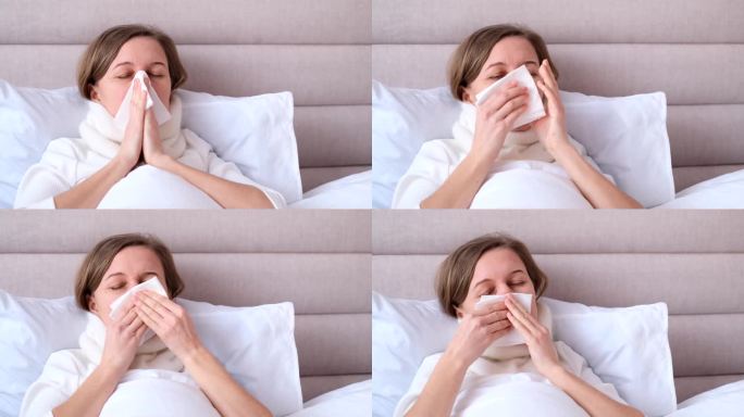 一名年轻女子在卧室的白色床上对着纸巾打喷嚏，流感和过敏的概念。