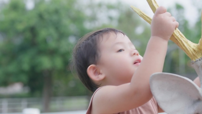 一个可爱的亚洲小男孩的特写脸在公园外面玩耍。面部表情和眼神探索。天真可爱的小婴儿。