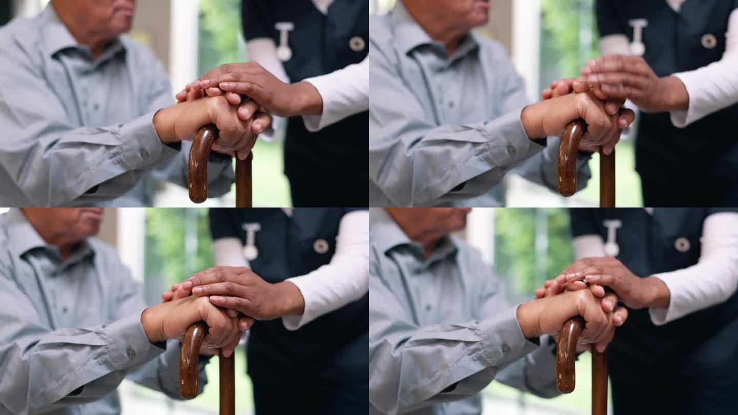 老人手牵着手，拄着拐杖，护士用特写镜头进行恢复、平衡和康复。退休，木手杖和残疾老人，养老院的照顾和同