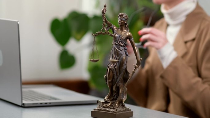 女律师在现代化的办公室里对着电脑工作。法律、法律服务、咨询和司法。