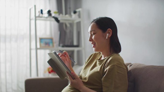 孕妇在家用数码平板电脑在线学习