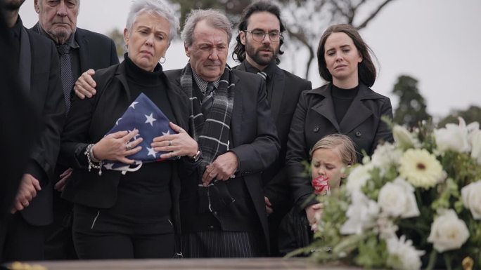 葬礼，墓地和家属与美国国旗的士兵表示尊重，仪式和追悼会。悲伤、沮丧的人们靠棺材在墓地里悼念军人、军队