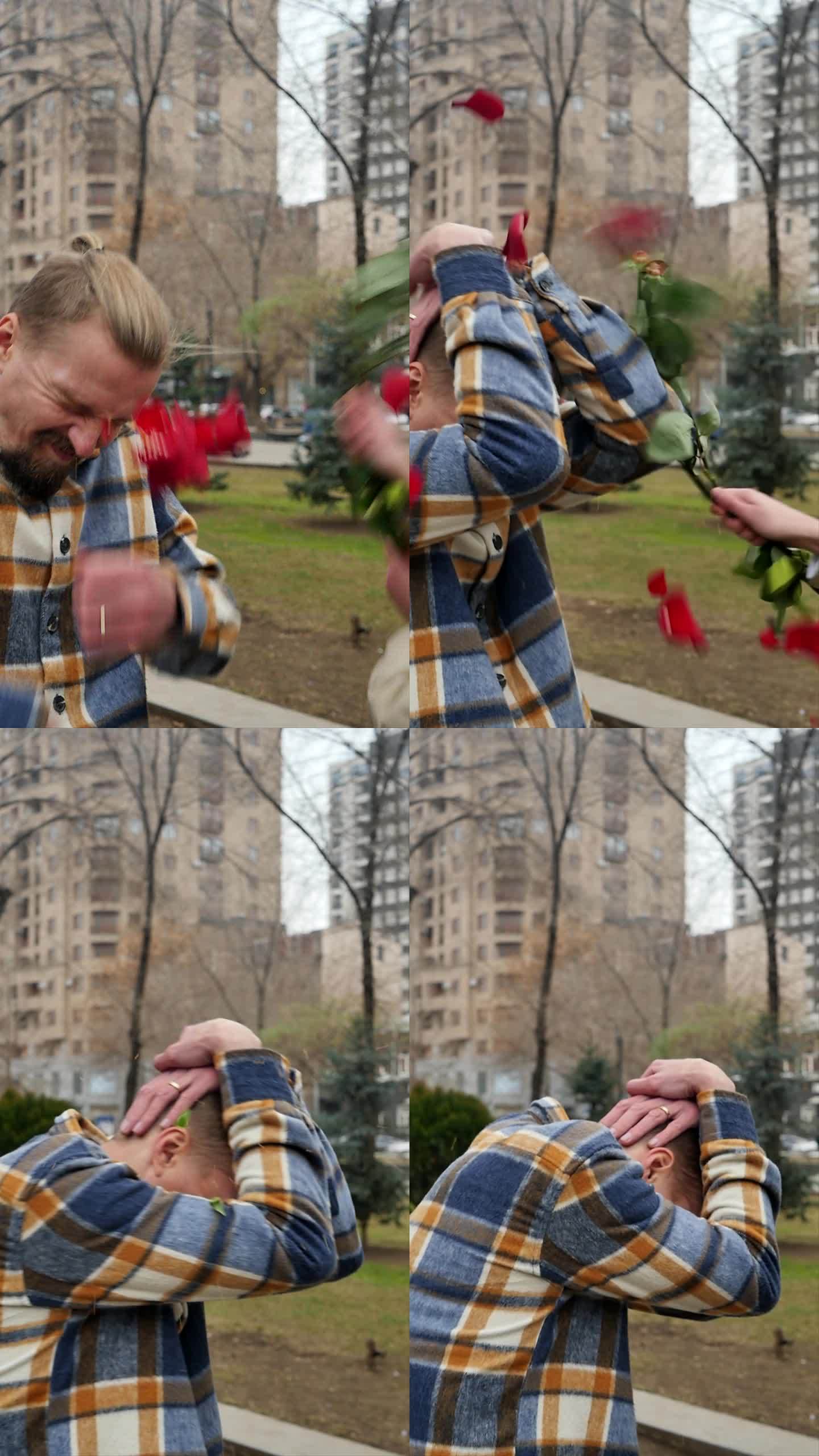 垂直画面:一个愤怒的女人用一束玫瑰花打了一个年轻人。一名男子用手捂住脸和头，以免被女友的鲜花殴打。用