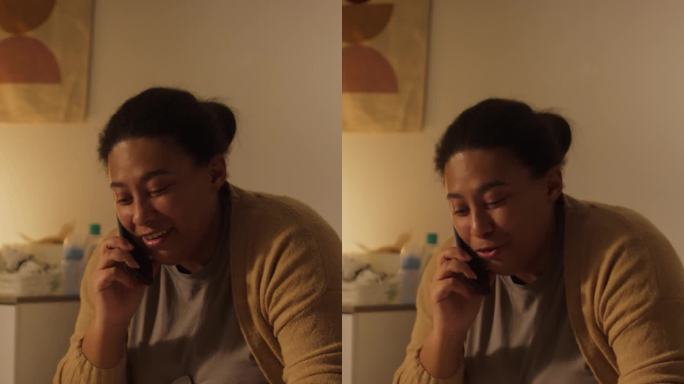 微笑的黑人妈妈陪着儿子玩手机聊天