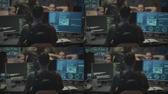 坐在电脑前的网络安全军事工作者的后视图