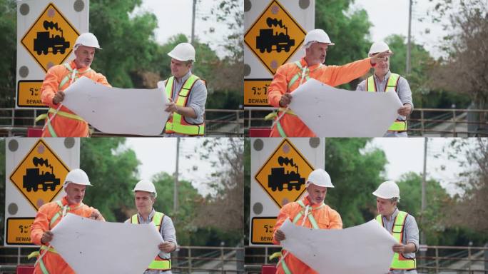 两位专业的美国高级铁路工程师在铁路施工现场一起工作，看着铁路轨道蓝图，仔细检查设计施工。