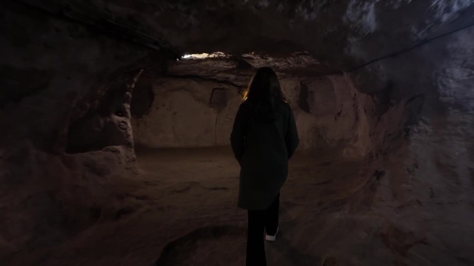 在公元前1200年建于土耳其卡帕多西亚的Derinkuyu地下城，一名年轻女子走在狭窄的隧道中。