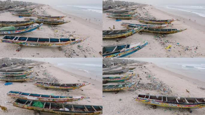 空中特写。色彩斑斓的独木舟、令人震惊的塑料污染和垃圾就躺在海洋的边缘。塞内加尔圣路易