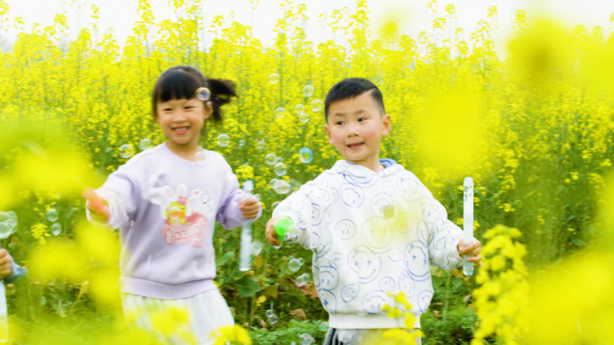 孩子油菜花中玩泡泡油菜花田春日春游户外