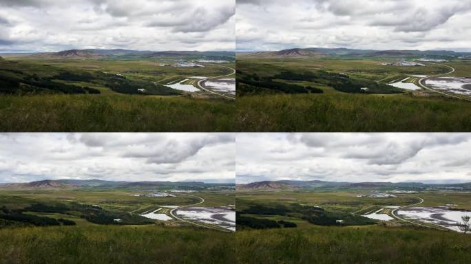 冰岛广阔的风景，群山和多云的天空，前景中的绿色植物