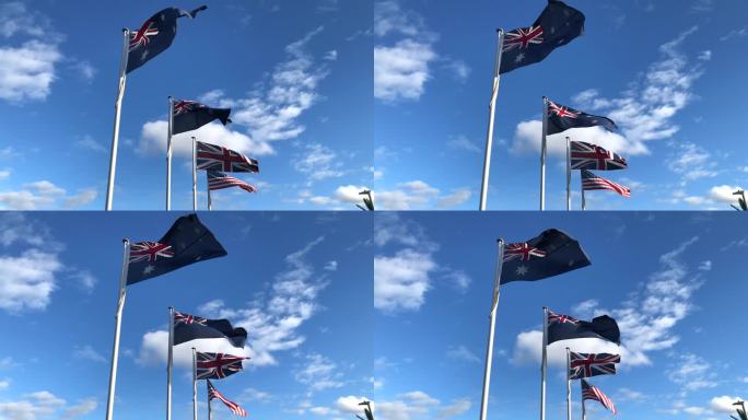 澳大利亚、新西兰、英国、美国等西方盟国的国旗在蔚蓝的天空下迎风飘扬。