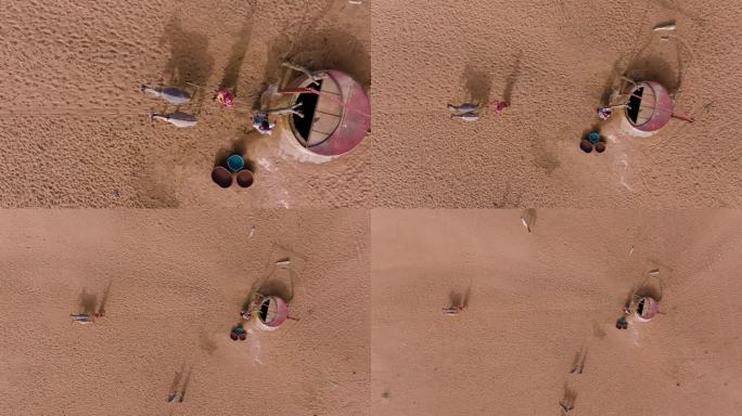 垂直向下的天线。在贫瘠的塞内加尔撒哈拉沙漠萨赫勒地区，两名黑人妇女在驴子的帮助下从深井中取水。干旱，