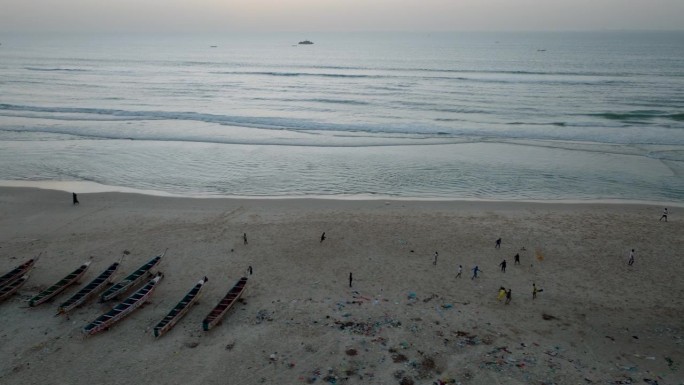空中平移。日落时分，孩子们在沙滩上踢足球，圣路易，塞内加尔，联合国教科文组织世界遗产