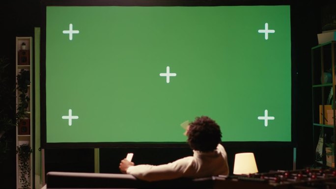 一名男子使用视频投影仪在基于订阅的流媒体服务上观看电视剧