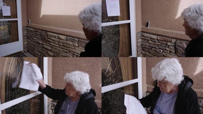 一位八十多岁的老妇人读着贴在她家前门的取消抵押品赎回权通知