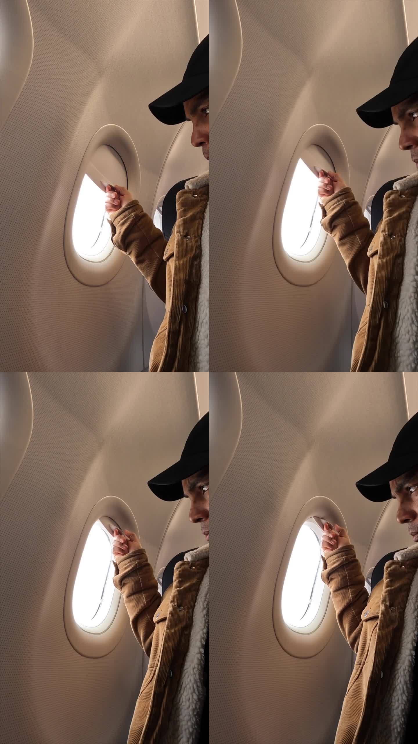 乘客在飞行途中用手打开飞机窗户