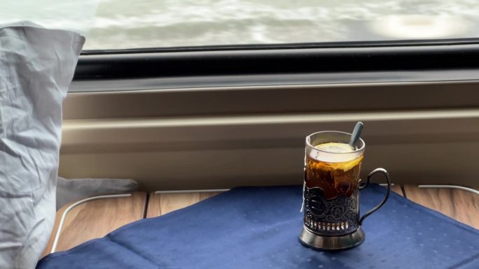 在长途火车上，一个带品牌的老式玻璃杯里的茶杯
