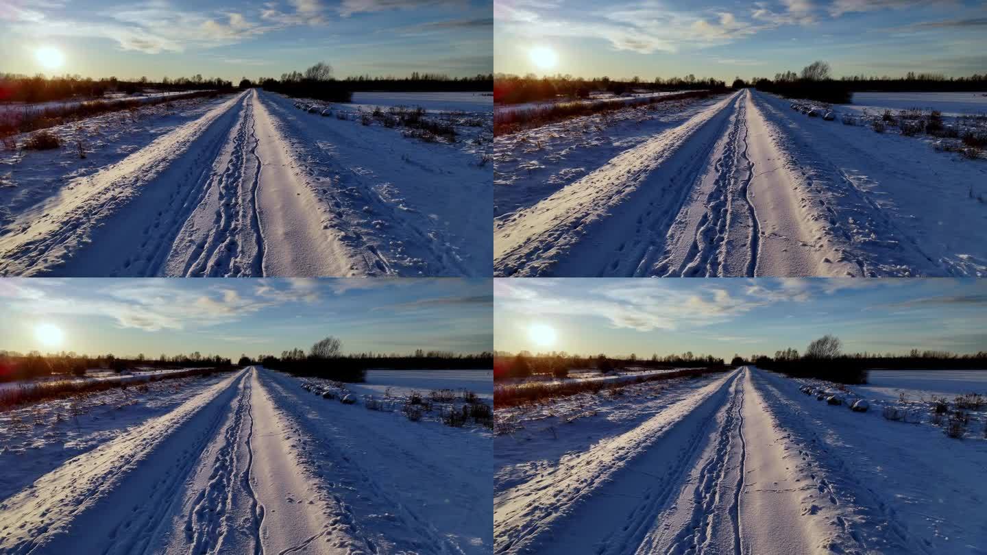 白雪覆盖的道路一直延伸到远处，天空湛蓝，夕阳投下长长的影子