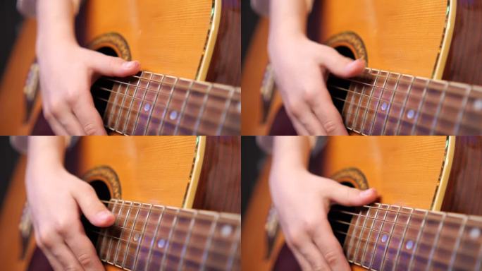 男孩用受伤的手指拨动吉他琴弦。努力学习理念