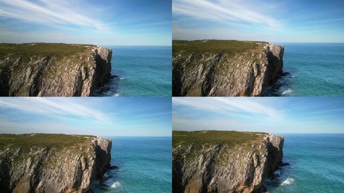 海中的一些悬崖的鸟瞰图，蓝绿色的海水与岩石碰撞，还有山后面的一些草地