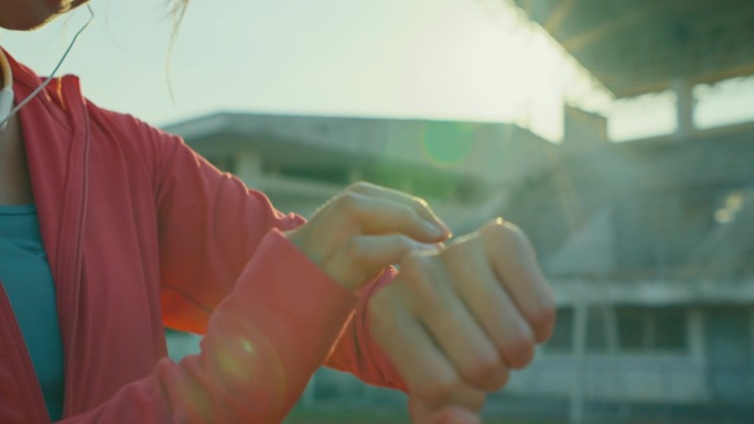 年轻的亚洲女运动员跑步者在户外跑步前检查智能手表的进度和看智能手表心率监测器的特写。健康的锻炼。