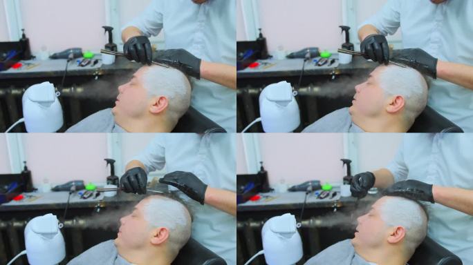 理发师在汽化器喷出的热气流下给一个男人剃头。