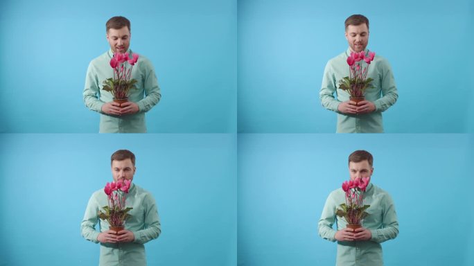 一名男子手持盆栽植物，背景为蓝色