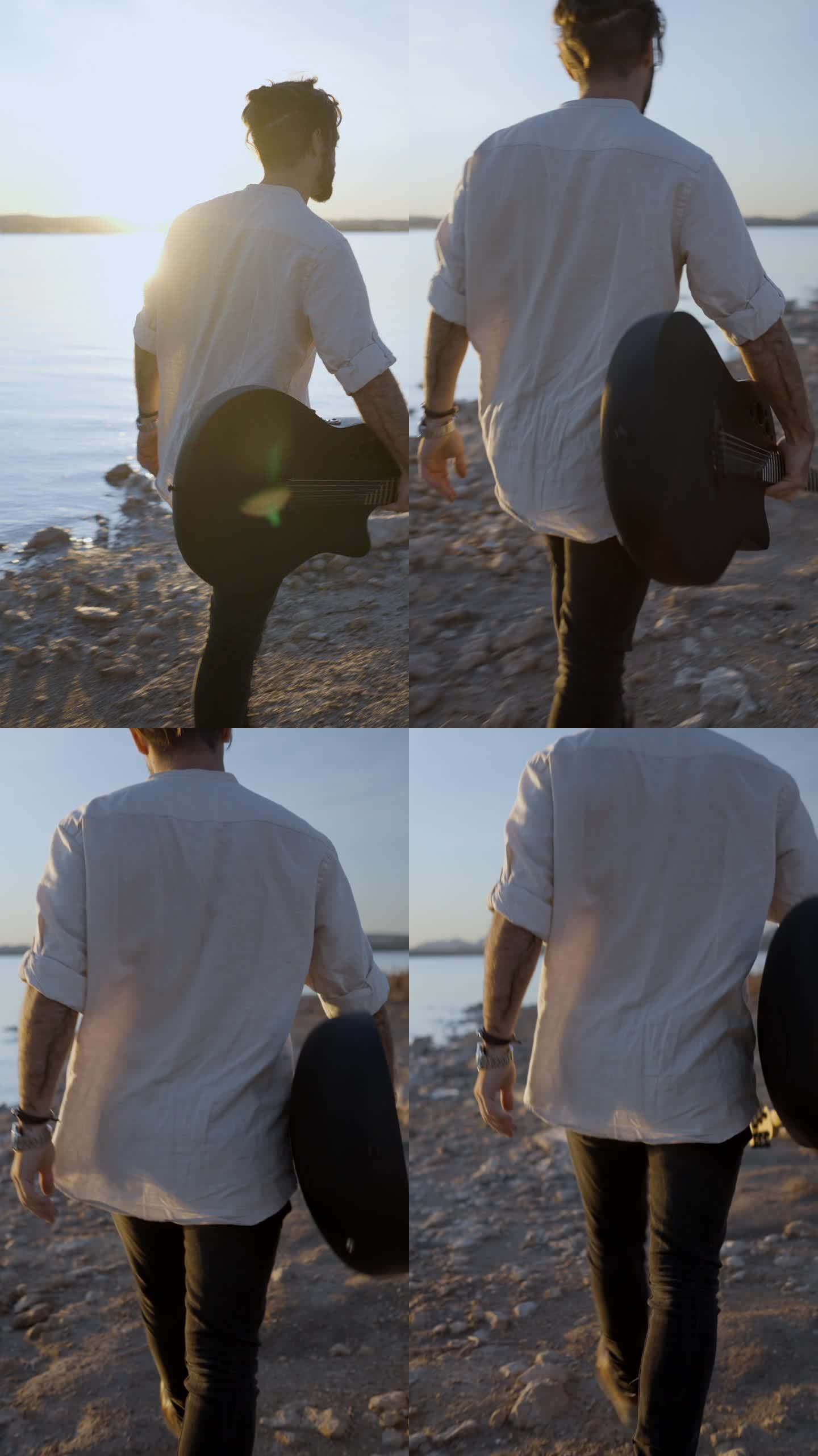 潮人带着吉他欣赏日落在湖岸的石头沙滩上散步对着太阳-慢动作的后景