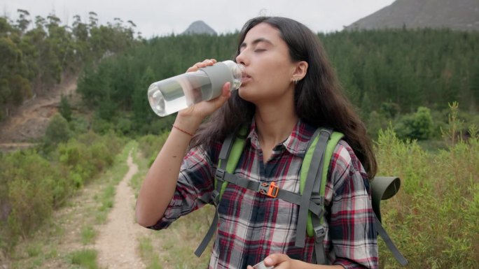 徒步旅行的女人，在冒险中喝水和瓶装水，在大自然中补水，排毒或健康。女孩，丛林徒步旅行和液体健康在森林