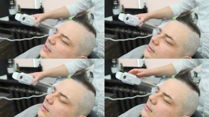 理发师引导一股蒸汽从蒸汽加湿器流到男人的头部