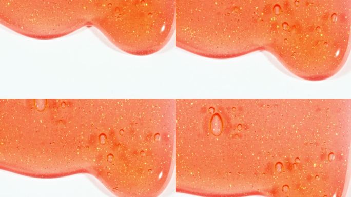 红色透明化妆品凝胶流体与分子气泡流动在白色的表面。微距镜头。液体乳霜凝胶透明化妆品样品纹理与泡沫。