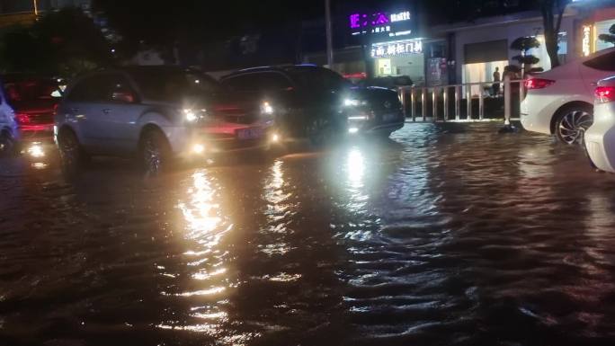 城市内涝涉水车辆在暴雨水中开车涉水城市