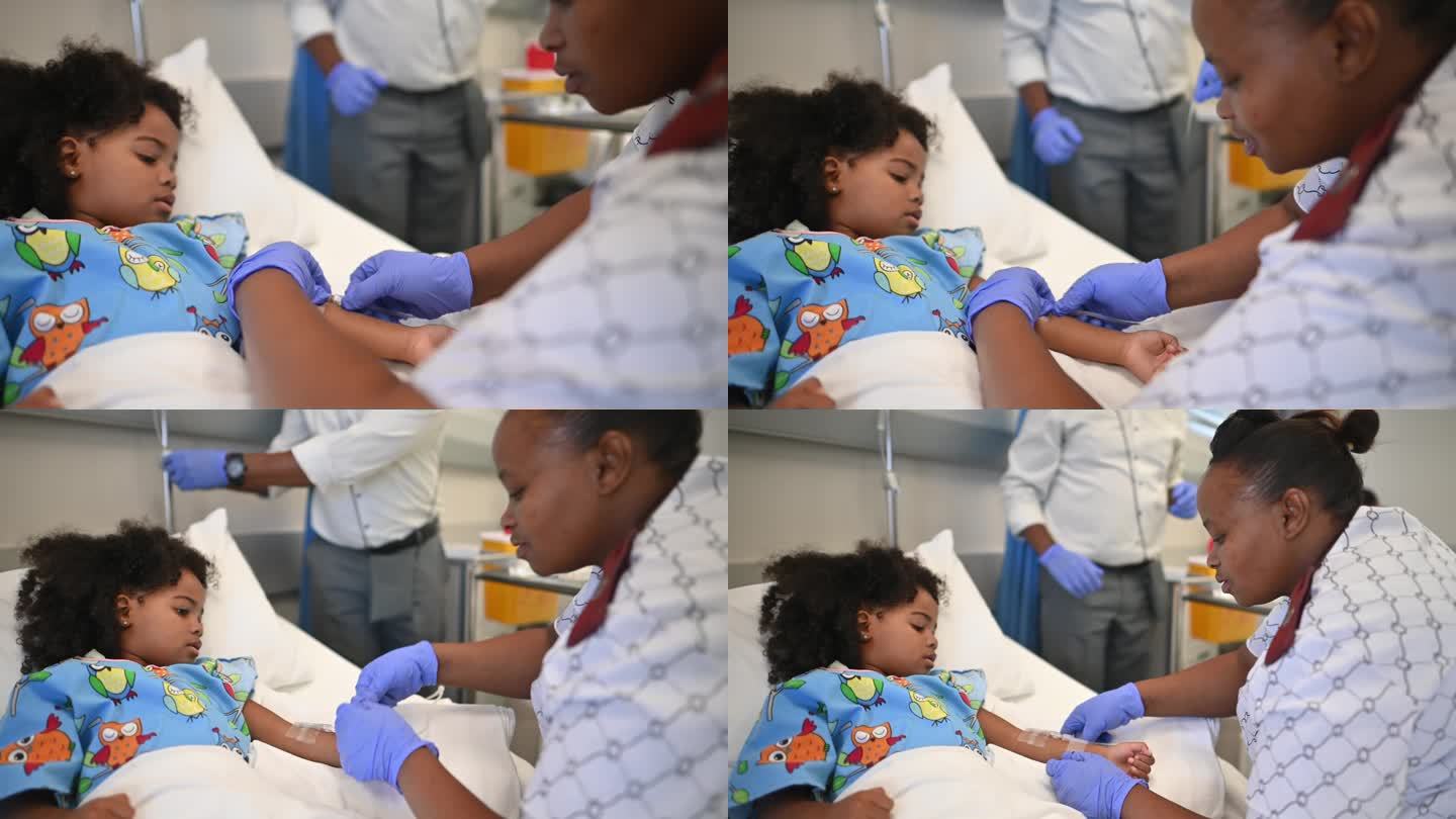 友好的非洲护士在病房的病床上给可爱的女孩手臂上打点滴，与她击掌