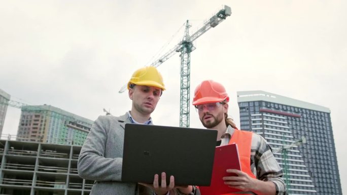 建筑承建商在工地视察时使用手提电脑