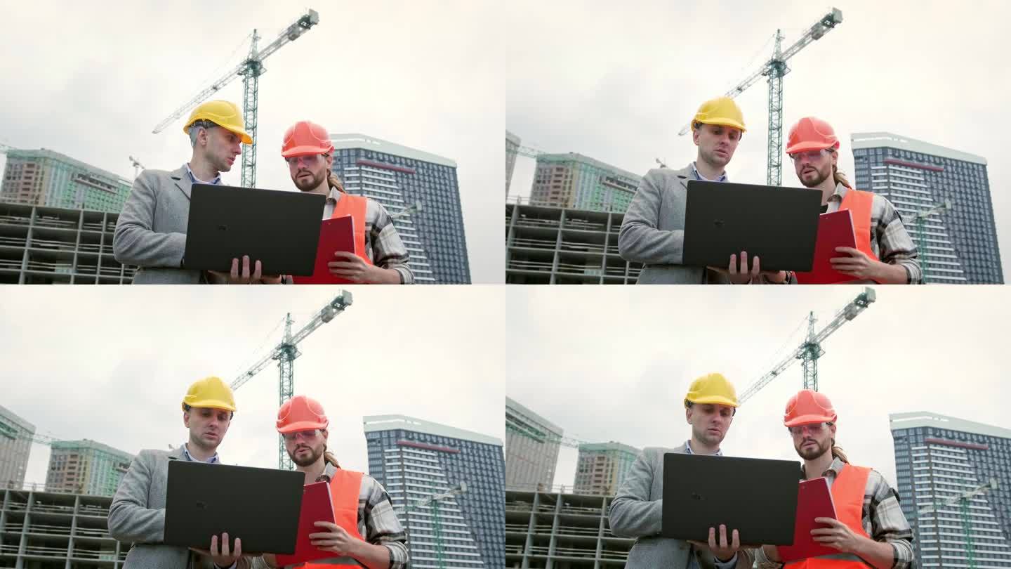 建筑承建商在工地视察时使用手提电脑