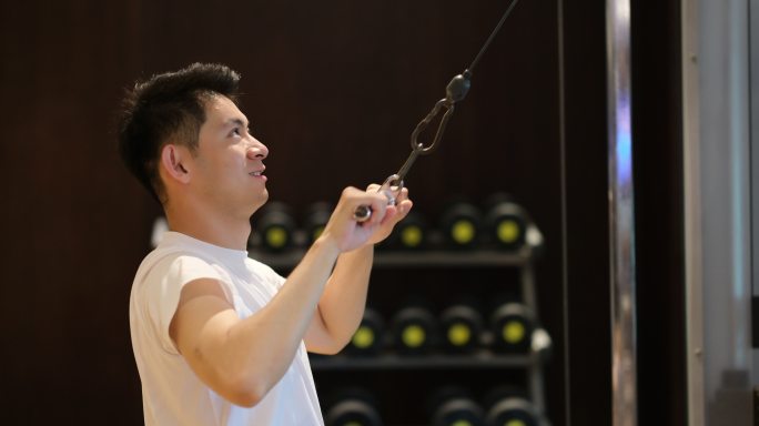 一位年轻中国男性在室内健身房健身锻炼身体